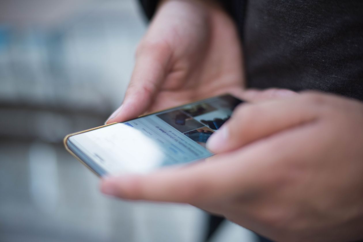 Personne utilisant un smartphone pour naviguer dans des paramètres de compte